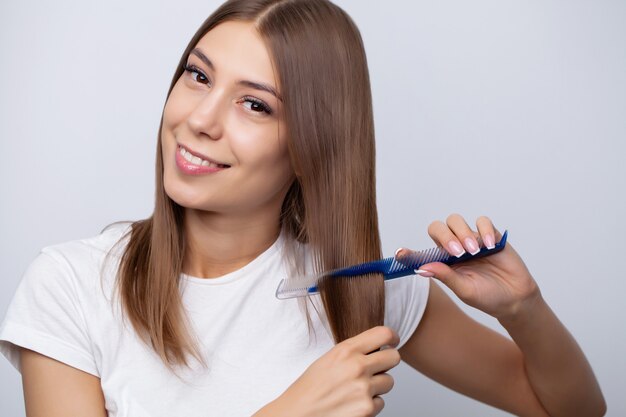 Pretty woman combs her hair at home