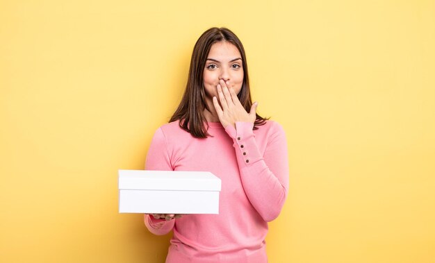 Pretty woman covering mouth with hands with a shocked white box packaging concept