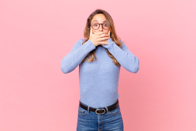 Pretty woman covering mouth with hands with a shocked