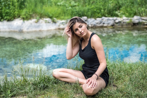 Pretty woman doing yoga meditation near lake, outdoors. healthy lifestyle