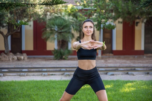 Bella donna che fa yoga nel parco mattutino stile di vita sano concezione all'aperto sport donna natura ritratto facendo esercizi stile di vita sano