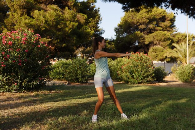 Красивая женщина занимается йогой в утреннем парке Концепция здорового образа жизни на открытом воздухе Спорт Женщина портрет природы делает упражнения Здоровый образ жизни