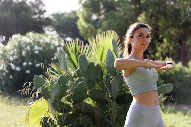 Pretty woman doing yoga in morning park Healthy lifestyle outdoor conception Sport Woman nature portrait doing exercises Healthy lifestyle