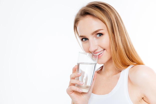 Bella donna che beve acqua isolata su uno sfondo bianco