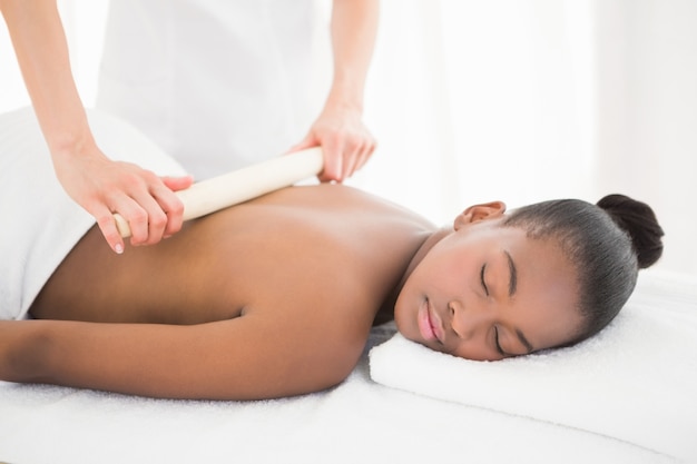 Pretty woman enjoying a bamboo roller massage