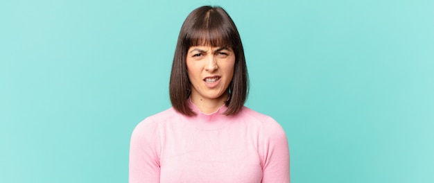 Photo pretty woman feeling disgusted and irritated, sticking tongue out, disliking something nasty and yucky