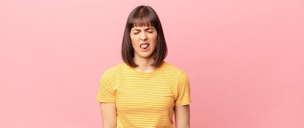 Photo pretty woman feeling disgusted and irritated, sticking tongue out, disliking something nasty and yucky
