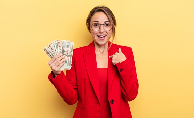 Pretty woman feeling happy and pointing to self with an excited business and dollar banknotes concept