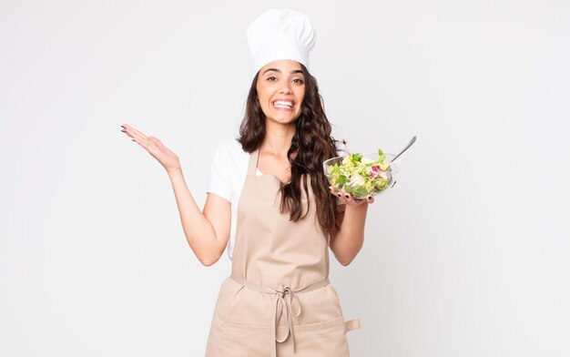 Pretty woman feeling happy, surprised realizing a solution or idea wearing an apron and holding a salad