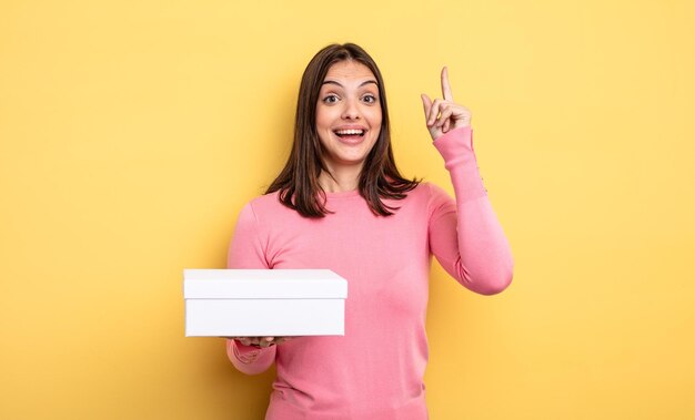 Pretty woman feeling like a happy and excited genius after realizing an idea. white box packaging concept