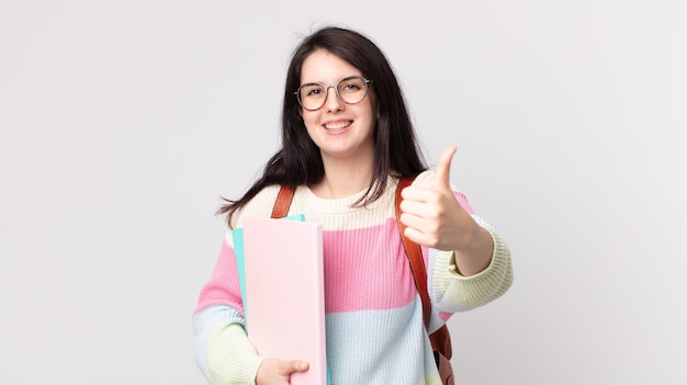 Pretty woman feeling proud,smiling positively with thumbs up. university student concept