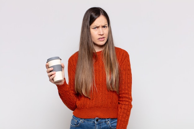 Foto bella donna che si sente perplessa e confusa, con un'espressione stupida e sbalordita che guarda qualcosa di inaspettato