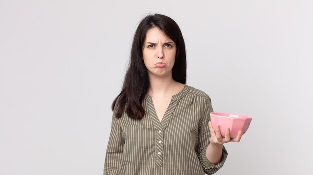 Pretty woman feeling sad and whiney with an unhappy look and crying holding an empty pot bowl. assistant agent with a headset