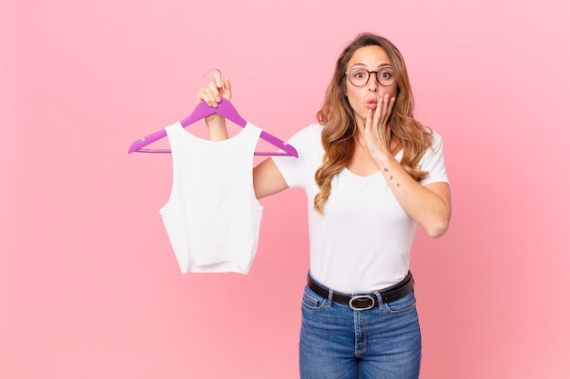 Pretty woman feeling shocked and scared and choosing clothes