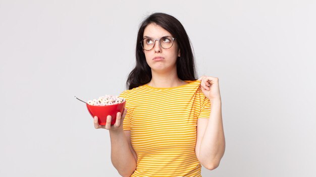 pretty woman feeling stressed, anxious, tired and frustrated and holding a breakfast bowl