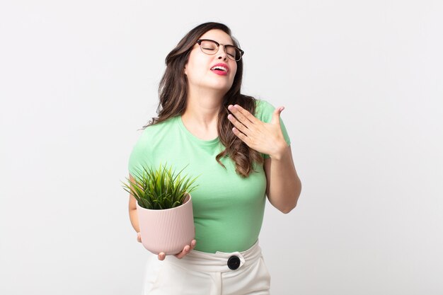 Pretty woman feeling stressed, anxious, tired and frustrated and holding a decorative plant