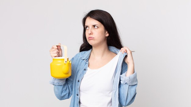 Pretty woman feeling stressed, anxious, tired and frustrated and holding a teapot