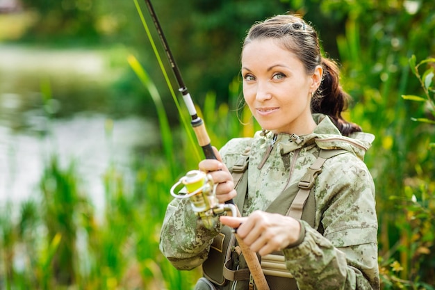 Pretty woman fishes on the river