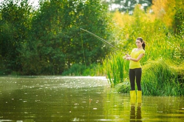 Pretty woman fishes on the river