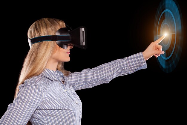 Pretty woman in grey shirt touching something curiously using the virtual reality headset