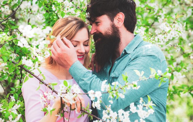 Pretty woman and handsome man walking in the spring Park and enjoying the beautiful spring blossom nature Green spring autumn couple