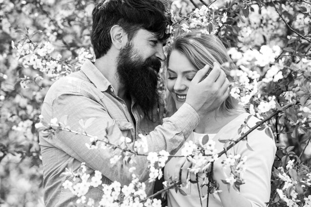 Pretty woman and handsome man walking in the spring Park and enjoying the beautiful spring blossom nature Green spring autumn couple