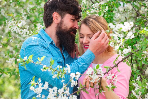 Pretty woman and handsome man walking in the spring Park and enjoying the beautiful spring blossom nature Green spring autumn couple