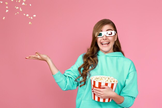 Pretty woman holding bucket with flying popcorn person