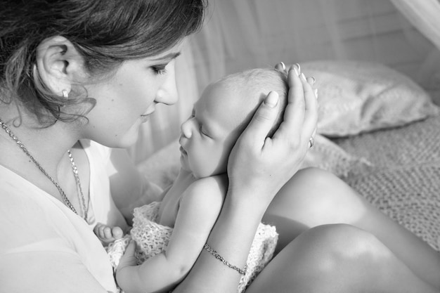 Donna graziosa che tiene un bambino appena nato in sue braccia