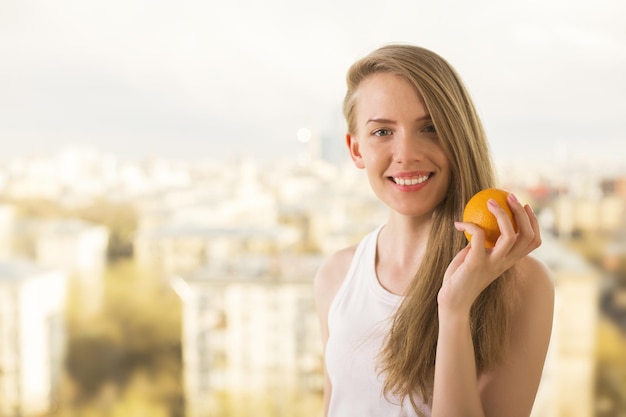 Pretty woman holding orange