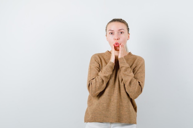 The pretty woman is showing surprised gesture on white background