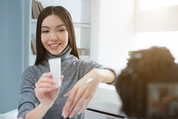 きれいな女性は窓の近くの部屋に座って、カメラを探しています