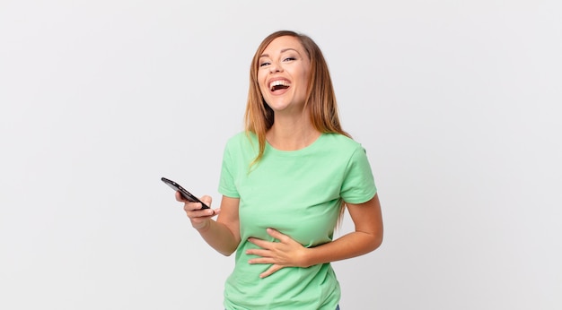 Pretty woman laughing out loud at some hilarious joke and using a smartphone