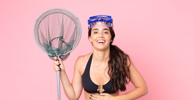 Pretty woman laughing out loud at some hilarious joke with goggles and a fisher net