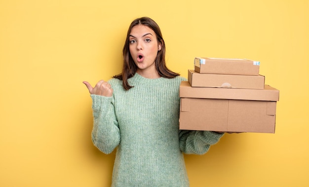 Pretty woman looking astonished in disbelief packages boxes concept