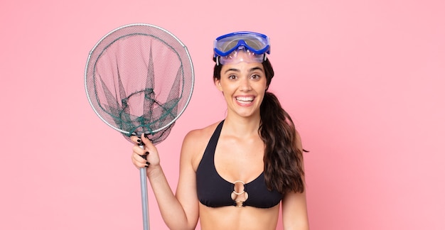 Pretty woman looking happy and pleasantly surprised with goggles and a fisher net