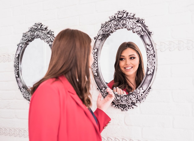 Photo pretty woman looking at mirror