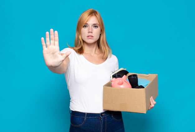 Pretty woman  looking serious, stern, displeased and angry showing open palm making stop gesture