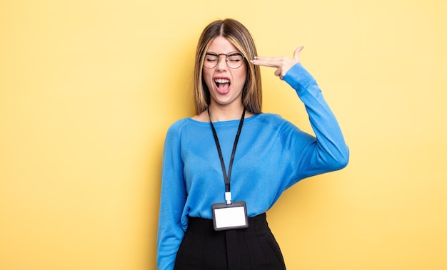 Pretty woman looking unhappy and stressed, suicide gesture making gun sign. accreditation card concept