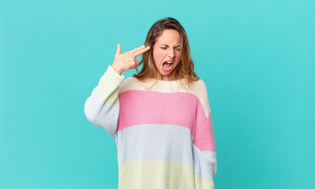 Pretty woman looking unhappy and stressed, suicide gesture making gun sign