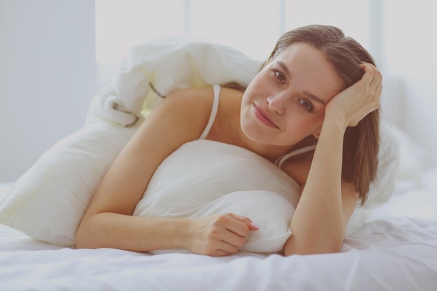 Pretty woman lying down on her bed at home