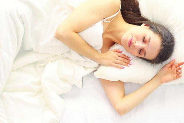 Pretty woman lying down on her bed at home