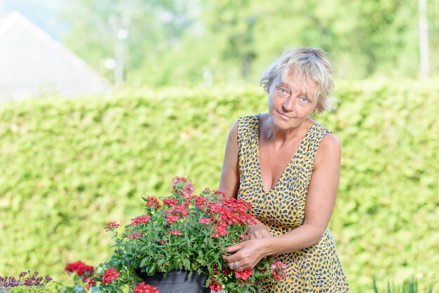 A pretty woman of middle age care flowers