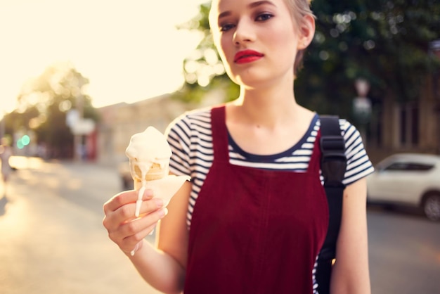 Pretty woman outdoors eating ice cream Summer sun relaxation