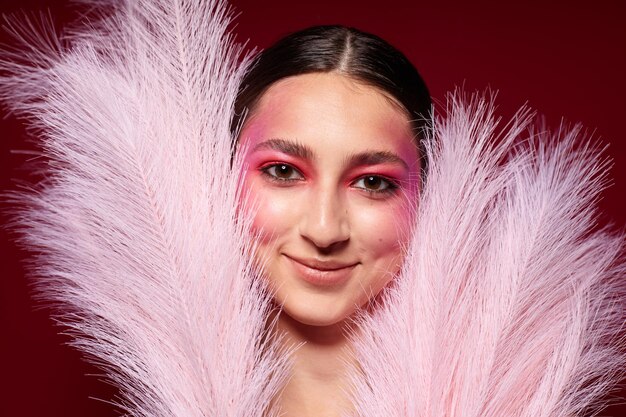 Pretty woman pink feathers pink face makeup posing attractive look closeup unaltered