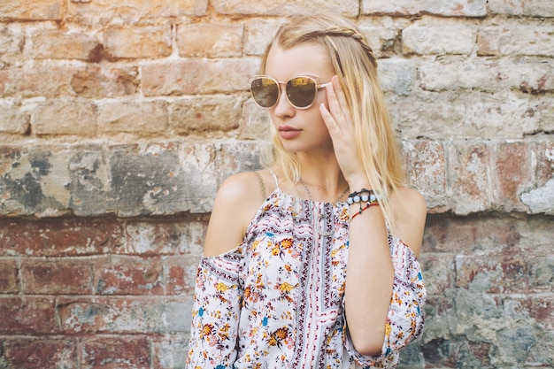 Pretty woman posing at brick wall