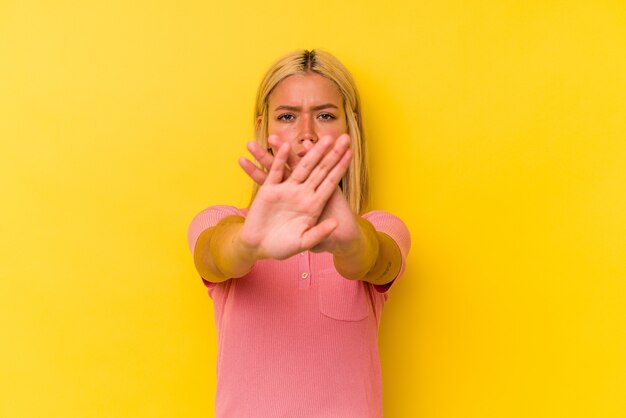 A pretty woman posing over yellow background