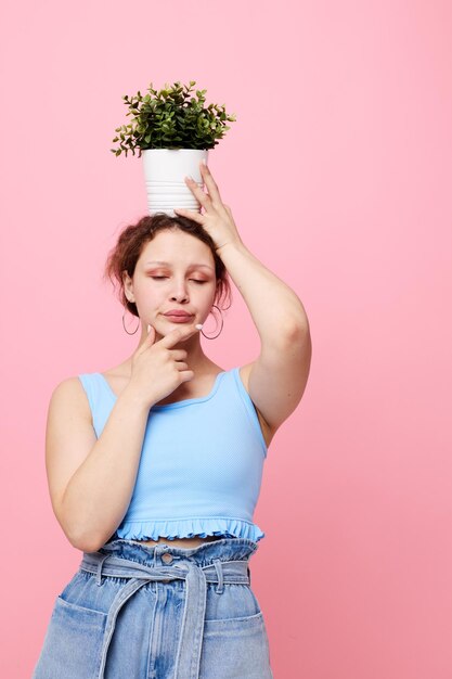 pretty woman potted flower posing plant pink background unaltered. High quality photo