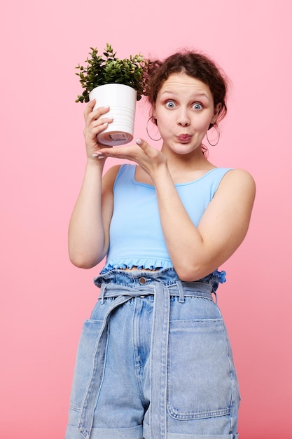 きれいな女性鉢植えの花のポーズ植物ピンクの背景は変更されていません