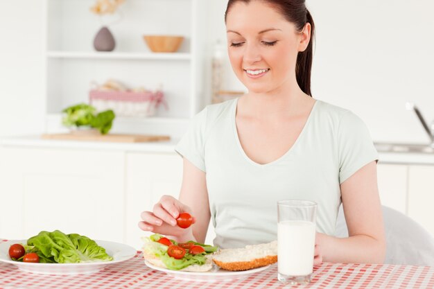 昼食のためにサンドイッチを食べる準備ができている可憐な女性